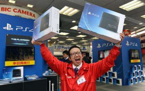 An employee of an electronics chain promotes the release of Sony's PlayStation 4 video game console, in Tokyo, on February 22, 2
