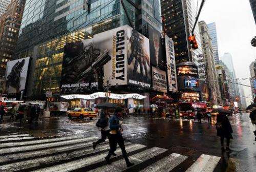 People walk past billboards advertising &quot;Call of Duty: Advanced Warfare&quot;  near Times Square in New York, November 6, 2
