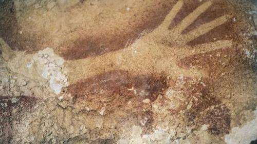 Researchers believe this silhouette of a hand on a cave wall in Indonesia is 40,000 years old. The picture was released by the j