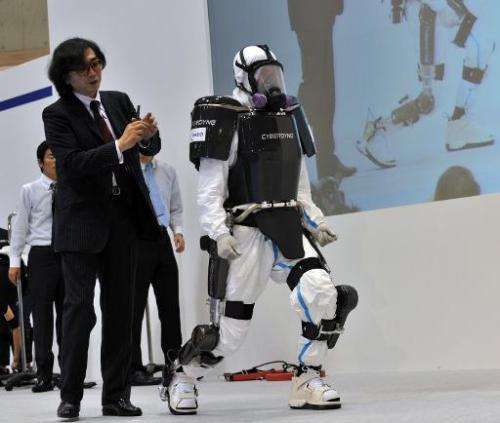 University of Tsukuba professor and president of Cyberdyne Yoshiyuki Sankai (L) unveils a robot suit at the Japan Robot Week exh