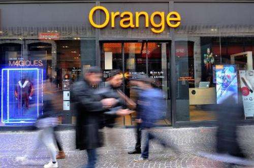A picture taken on February 24, 2014 in the French northern city of Lille, shows people walking in front of an Orange store