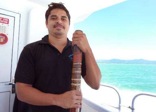Aboriginal Australian Gavin Singleton stands with his digderidoo on a boat travelling to the Great Barrier Reef