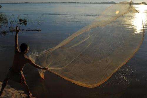 A Cambodian man throws a fishing net in the Mekong river in Phnom Penh on August 21, 2011