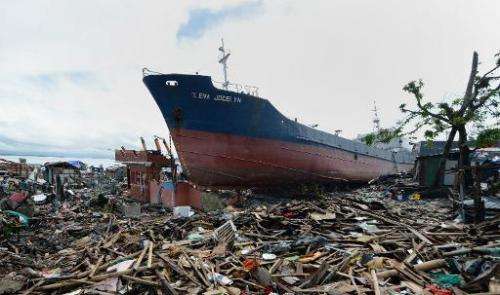 A cargo ship swept ashore at the height of Super Typhoon Haiyan still rests amongst debris and destroyed houses in Tacloban, Phi