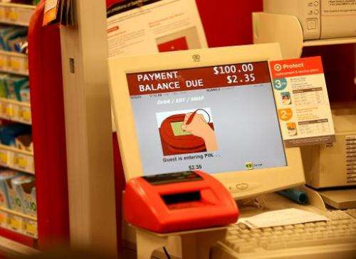 A cash register screen indicates a customer is entering their PIN number at a Target store on December 19, 2013 in Miami, Florid