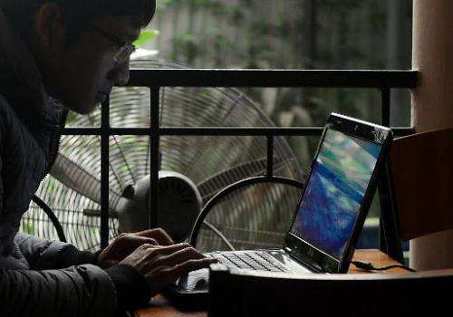 A customer is seen using a laptop at a coffee shop in Hanoi, Vietnam, on November 28, 2013
