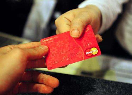 A customer pays his restaurant bill with a credit card in Seoul on April 11, 2011