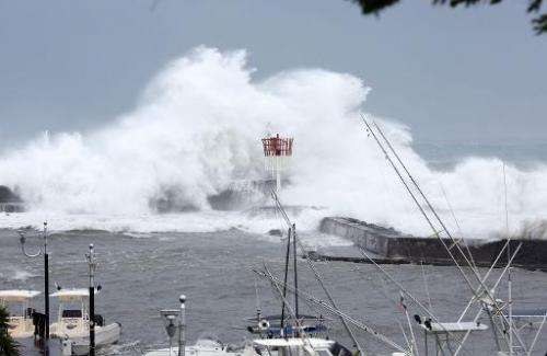 A cyclonic swell sweeps a pier on January 2, 2014 in Saint-Gilles, in the French La Reunion overseas island