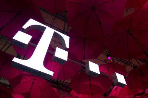 A Deutsche Telekom T-Mobile logo hangs under pink umbrellas at the stand of the German telecommunications giant at the 2014 CeBI