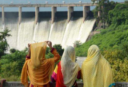 A family looks at the Rawal dam spill way during the Eid holidays in Islamabad on August 10, 2013