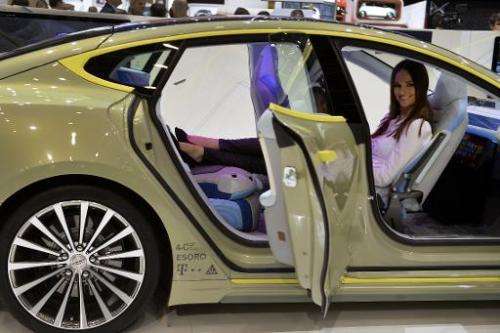 A hostess poses inside the new Rinspeed &quot;XchangE&quot; concept car displayed at the Swiss carmaker's booth during the press