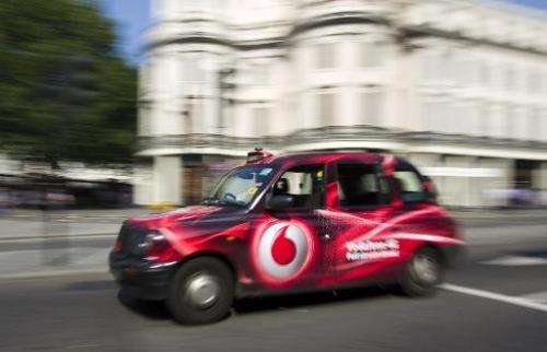 A London black taxi branded with a Vodafone 4G advertisement drives through central London on September 4, 2013