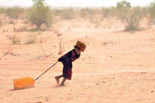 A Malian refugee pulls a jerrican of water at the Mbere refugee camp on May 3, 2012, near Bassiknou, southern Mauritania