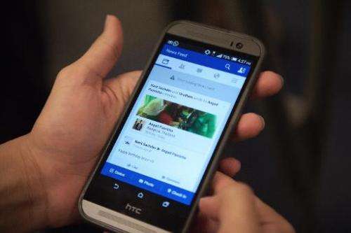 A man check his Facebook account on his smart phone with a message reading, &quot;error loading news feed&quot; in Bangkok on Ma