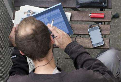 A man is seen working on an iPad, on a balcony in Berlin, Germany, on June 23, 2011