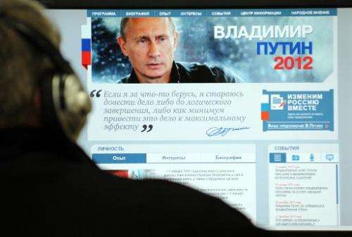 A man looks at a computer monitor displaying the main page of Russian Prime Minister Vladimir Putin's election campaign website,