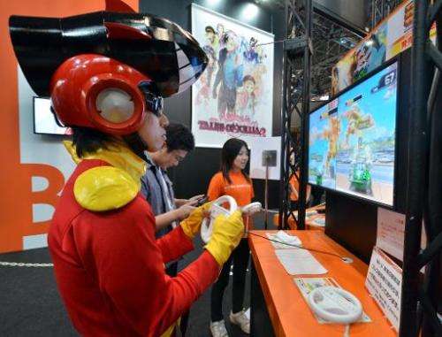 A man plays a videogame on Nintendo's Wii U at a booth of Japanese software house Bandai Namco at the annual Tokyo Game Show in 