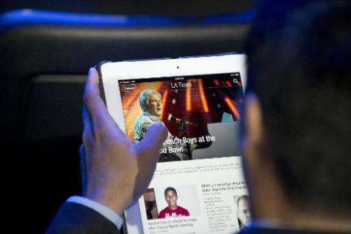 A man reads a newspaper article using the Flipboard app on an iPad in Los Angeles, on June 5, 2012