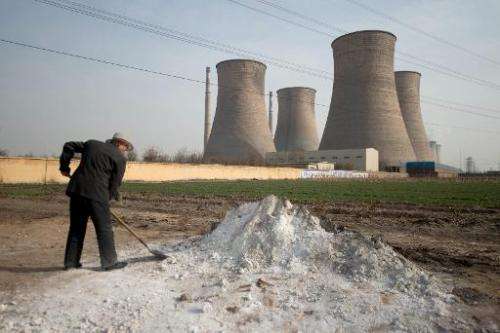 A man shovels earth in a field outside a power plant in Xingtai, southern Hebei province, on March 10, 2013