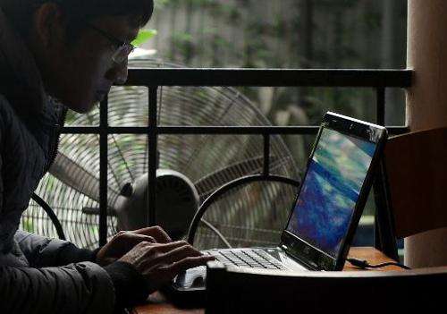 A man uses a laptop at a coffee shop in downtown Hanoi on November 28, 2013