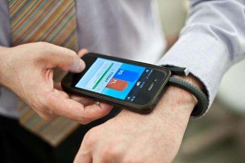 A man uses an UP fitness wristband and its smartphone application in Washington on July 16, 2013