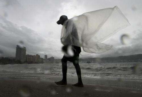 A man walks on the beach during a tropical storm in Acapulco, Guerrero State, Mexico on September 17, 2014