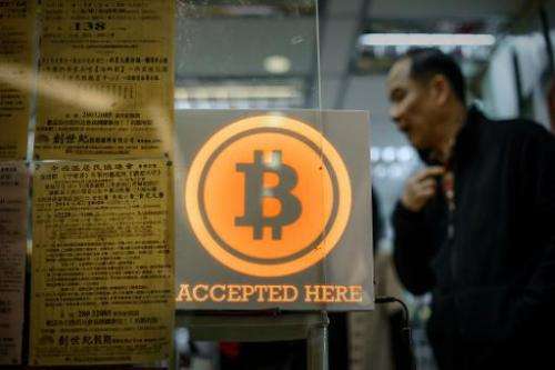 A man walks out of a shop displaying a bitcoin sign during the opening ceremony of the first bitcoin retail shop in Hong Kong on