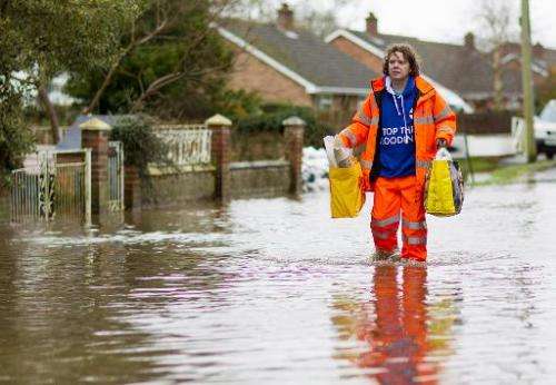 A man walks through flooded streets in the village of Moorland in Somerset, south-west England, on February 6, 2014