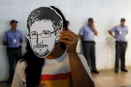 A member of the Avaaz online community organization wears a &quot;Snowden&quot; mask in Brasilia, on February 13, 2014