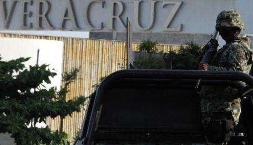 A Mexican Marine stands guard over a truck at a check point in the city port of Veracruz, Mexico on September 9, 2012