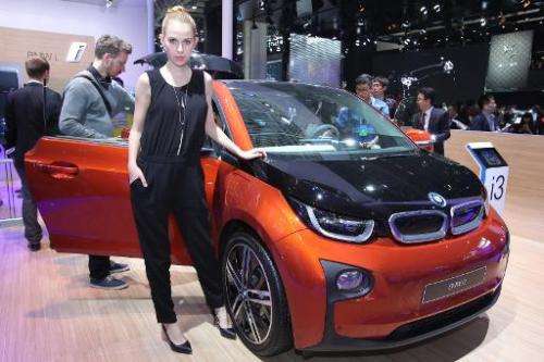 A model poses by an i3, a BMW electric car, on display at the Beijing Automotive Exhibition on April 20, 2014