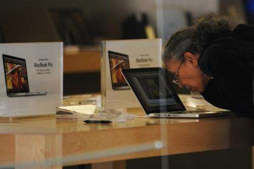 An elderly woman checks out a laptop computer at an apple store in Bethesda, Maryland, on May 12, 2010