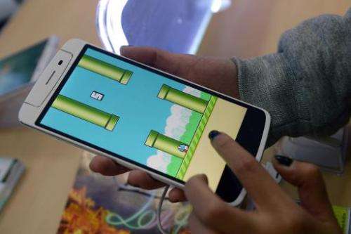 An employee plays the game Flappy Bird at a smartphone store in Hanoi on February 10, 2014