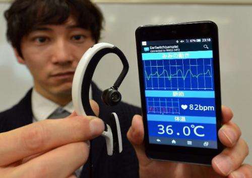 An engineer of Japanese machinery maker NS West shows the 'Earclip-type Wearable PC', equipped with vital sensors, such as pulse