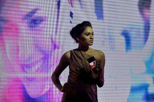 An Indian model showcases the new Samsung 'Galaxy S5' smartphone during a fashion show held as part of a consumer event in Banga