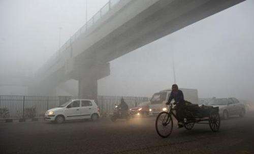 An Indian rickshaw passes under a bridge in New Delhi on January 31, 2013 as pollution hits hazardous levels around the city