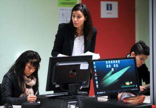 An instructor teaches a computer course for students who have dropped out of school in Saint-Andre-lez-Lille on January 7, 2014