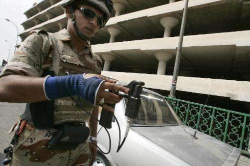 An Iraqi soldier uses an explosive detector-device at a checkpoint in central Baghdad, October 17, 2007