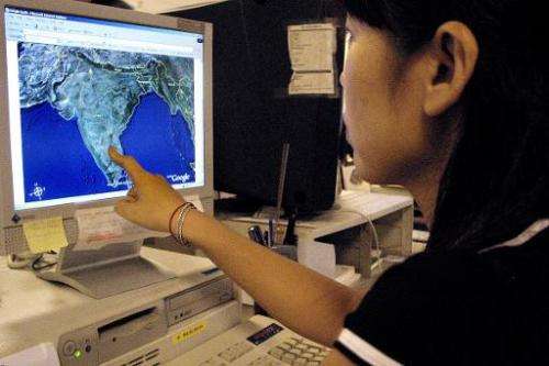 An office worker checks out a map on Google's satellite image service, in Hong Kong, on October 18, 2005