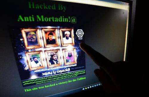 A Pakistani points at a computer screen showing the hacked official website of Rawalpindi police on May 15, 2014