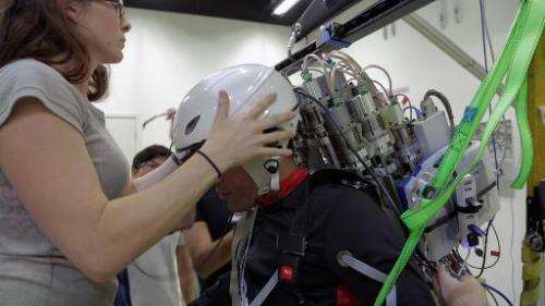 A paraplegic patient (R) wears an interface helmet at Brazilian scientist Miguel Nicolelis' lab in Sao Paulo, Brazil, on January