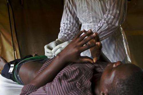 A patient is fitted with a non-surgical circumcision device called PrePex in Mukono on May 12, 2014, it is hoped it could cut HI