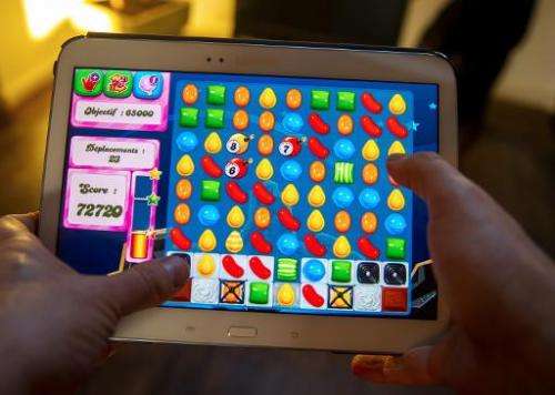 A person plays on his tablet Candy Crush Saga game, developed by King Digital Entertainment, in Lille, northern France, on March