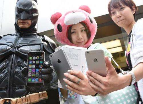 Apple fans show off their new iPhone 6 handsets at an Apple store in Ginza, Tokyo on September 19, 2014