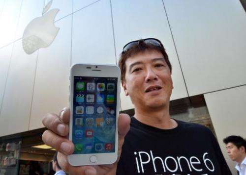 Apple fan Tetsuya Tamura holds a China made 'iPhone 6' outside an Apple store in Tokyo on September 12, 2014