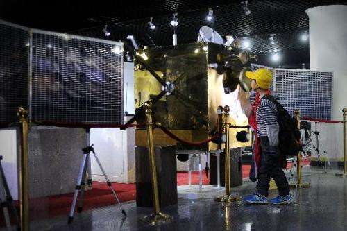 A pupil looks at the Chang'e-1 satellite at an astronomy museum in Beijing on December 11, 2013