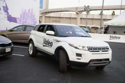 A Range Rover Evoque equipped with Valeo self-parking technology backs into a parking spot during a driverless car demo at the 2