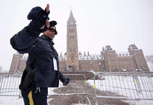 A Royal Canadian Mounted Police (RCMP) officer checks a security perimeter in front of the Parliament building in Ottawa, Ontari