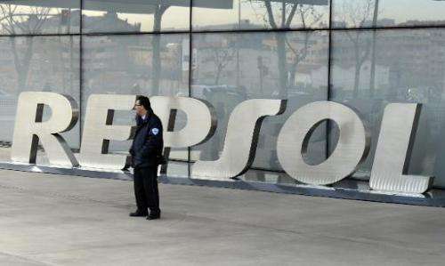 A security guard stands outside the main entrance to Spanish oil giant Repsol's headquarters in Madrid on January 24, 2014