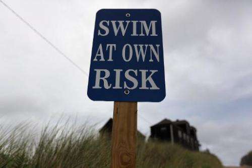 A sign reads, &quot;Swim at Own Risk&quot; at Ballston Beach on Cape Cod on August 12, 2012 in Truro, Massachusetts